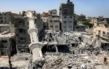 Des Palestiniens au milieu des destructions, dont le minaret effondré d'une mosquée, après des bombardements israéliens à Nousseirat dans le centre de la bande de Gaza, le 17 juillet 2024