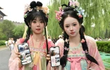Des touristes originaires de la province de Jilin, dans le nord-est de la Chine, montrent leurs comptes Xiaohongshu sur leurs téléphones alors qu'elles visitent la Cité interdite à Pékin, le 11 juillet 2026