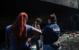 Des membres du Cabinet médical de rue parle avec un sans-abri, dans les environs de Rio de Janeiro, le 31 juillet 2023 au Brésil