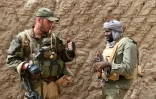 Un militaire malien (d) et un soldat français du 93e régiment d'artillerie de montagne membre de la force française Barkhane discutent ensemble le 3 juin 2015 à Goundam dans la région de Tombouctou au Mali