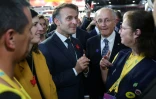 Le président français Emmanuel Macron se tient aux côtés du PDG du groupe La Poste, Philippe Wahl, et d'employés de La Poste au salon VivaTech, à Paris, le 11 juin 2025