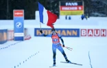 Julia Simon savoure la victoire des Bleues avant de franchir la ligne d'arrivée du relais 4x6 km de biathlon à Ruhpolding, le 14 janvier 2022 