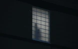 Une personne présumée détenue se tient près d'une fenêtre au centre fédéral d'immigration de Delaney Hall, utilisé comme centre de détention de l'Immigration and Customs Enforcement (ICE) à Newark, dans le New Jersey, le 29 mai 2026