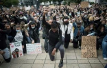Des manifestants, genou à terre, lève le poing, lors d'un rassemblement contre le racisme et les violences policières, le juin 2020 à Nantes