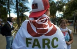 Un militant des Farc enveloppé dans un drapeau avec un logo du nouveau parti politique "révolutionnaire" à Bogota, le 1er septembre 2017