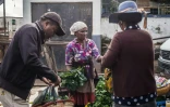 Nirina Ravololona (c) vend du gingembre et des citrons au marché d'Ambodivona, le 26 mars 2020 à Antananarivo, capitale de Madagascar
