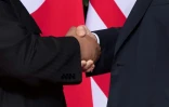 Le président américain Donald Trump (D) serre la main du leader Nord Coréen Kim Jong Un (G) lors du sommet historique à l'hôtel Capella à Singapour le 12 juin 2018
