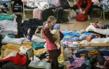 Une petite fille tient un bébé dans un abri pour réfugiés ukrainiens à Przemysl, en Pologne, près de la frontière ukrainienne, le 14 mars 2022