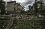 Un homme passe devant une école détruite par les bombes à Bakhmout, dans le Donbass (est de l'Ukraine), le 28 mai 2022