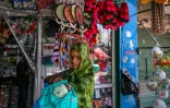 Une habitante, son enfant dans les bras, passe devant des boutiques du marché de Poonch, où le calme est revenu après le cessez-le-feu avec le Pakistan, le 11 mai 2025 en Inde 