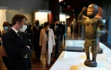 Emmanuel Macron et une statue du roi du Bénin Ghezo du XIXe au musée du quai Branly, à Paris le 27 octobre, 2021