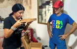 Tania Duyos (g) et l'artisan Alain Perez sentent l'odeur d'une pièce en bois de cèdre, le 5 septembre 2023 à La Havane, à Cuba