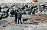 La garde civile espagnole avec un migrant qui vient d'arriver à la nage dans l'enclage de Ceuta, depuis le Maroc voisin, le 17 mai 2021