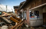 Une affiche du Premier ministre japonais Fumio Kishida sur un bâtiment en ruine le 5 janvier 2024  à Shiromaru au Japon après un tsunami provoqué par le séisme du Nouvel An