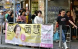 Des passants devant des affiches électorales dans le quartier de Wanchai à Hong Kong le 22 novembre 2019