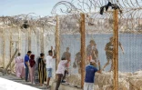 Des proches de migrants ayant traversé la frontière entre le Maroc et l'enclave espagnole de Ceuta voient passer des personnes refoulées derrière un grillage, dans la ville marocaine de Fnideq, le 2 août 2026