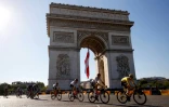 Le Slovène Tadej Pogacar (d) devant l'Arc de Triomphe lors de la 21e et dernière étape du Tour de France, entre Chatou et Paris, le 18 juillet 2021
