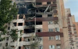 Des passants sont rassemblés devant un bâtiment visé par une frappe israélienne dans la capitale iranienne, Téhéran, le 13 juin 2025