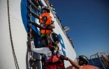 Un membre de l'équipe de l'Aquarius tient dans des bras une petite fille, en en mer Méditerrannée, au large de la côté lybienne 