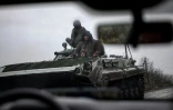 Des soldats ukrainiens en véhicule blindé sur une route près de Bakhmout, le 13 avril 2023 dans la région de Donetsk
