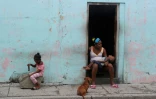 Une mère est ses enfants attendent l'arrivée de l'ouragan Matthew dans la ville de Guantanamo à l'ouest de Cuba, le 4 octobre 2016