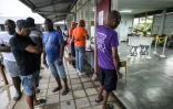 Des électeurs attendent pour voter lors des élections législatives, le 25 mai 2025 à Paramaribo, au Suriname