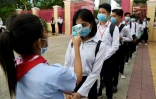 Des élèves masqués se font prendre leur température le 7 septembre à Phnom Penh au Cambodge, lors de la rentrée des classes