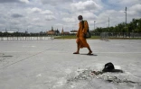 Un moine passe devant l'endroit où des manifestants pro-démocratie avaient fixé une "plaque du Peuple" le 20 septembre 2020 pour défier la monarchie thaïlandaise, qui a depuis été enlevée, le 21 septembre 2020 à Bangkok