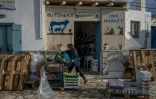 Poppi Prasinou installe des cagettes de légumes devant sa supérette, sur l'île grecque d'Amorgos, le 15 février 2025