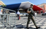 Un soldat en patrouille pendant l'installation des tribunes aux couleurs bleu-blanc-rouge sur la place Masséna de Nice, le 12 juillet 2017 