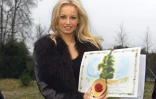 Adriana Karembeu présente le certificat d'adoption du tilleul qu'elle vient de planter dans le parc de Versailles, le 12 décembre 2000, le premier des 120 tilleuls offerts par le président slovaque Rudolf Schuster après les dommages de la tempête du 26 décembre 1999