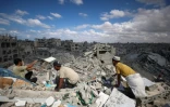 Des Palestiniens fouillent les décombres d'immeubles détruits par des bombardements israéliens à Khan Younès, dans le sud de la bande de Gaza, le 12 octobre 2025