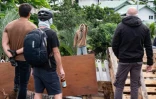 Des habitants masqués regardent un activiste à l'entrée du quatrier de Tuband, à Nouméa, le 15 mai 2024 en Nouvelle-Calédonie