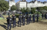 Des policiers entourent un camp de migrants en cours d'évacuation, le 23 juillet 2018 à Nantes