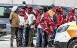 Des migrants attendent après avoir débarqué d'un navire, après leur sauvetage en mer alors que leur embarcation avait pris feu lors d'une tentative de traversée de la Manche, au port de commerce de Boulogne-sur-Mer, le 4 août 2026