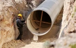 Un ouvrier devant une nouvelle canalisation installée par la compagnie nationale des eaux israélienne, à l'ouest du lac de Tibériade