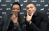 Le joueur du PSG Kylian Mbappé (d) et la légende brésilienne Pelé à l'Hôtel Lutetia à Paris le 2 avril 2019