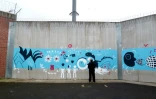 Un détenu devant une fresque réalisée par ses compagnons de cellule dans le cadre du programme "Respecto" de la maison d'arrêt de Villepinte, le 14 octobre 2016