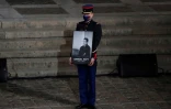 Un garde républicain tient le portrait de l'enseignant assassiné Samuel Paty lors de l'hommage national lui étant rendu le 21 octobre 2020 à la Sorbonne à Paris 