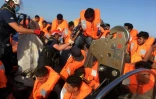 Des migrants secourus en mer par l'ONG SOS Mediterranée montent à bord du bateau Ocean Viking, le 25 juin 2020 large de l'île italienne de Lampedusa