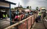 Des Congolais font la queue à une station de lavage des mains sur une route entre Butembo et Goma, dans l'Est de la RDC, le 16 juillet 2019