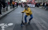 Un enfant portant un masque afin de se protégéer contre d'éventuels tirs de gaz lacrymogènes fait de la trottinette lors de la manifestation contre la loi travail à Rennes le 9 avril 2016