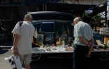 Des visiteurs regardent un étal du marché aux puces de Potchaiïna à Kiev, endommagé par une  une frappe russe, le 9 août 2026 à Kiev, en Ukraine