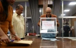 Un assesseur vide l'urne pour commencer le dépouillement du 1er tour des législatives dans un bureau de vote à La Possession, sur l'île de La Réunion, le 30 juin 2024