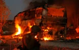 Les forces de sécurité israéliennes et les pompiers se rassemblent près d'un bus incendié après avoir été touché par une roquette tirée depuis la bande de Gaza, près du kibboutz de Kfar Aza, le 12 novembre 2018