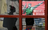 Une femme passe devant une affiche du défunt dirigeant cubain Fidel Castro sur laquelle on peut lire "Mort à l'envahisseur", à La Havane, le 13 mars 2026
