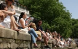 Des personnes assises au bord de la Tamise à Richmond, dans l'ouest de Londres, alors que les températures devraient grimper encore, le 23 mai 2026 au Royaume-Uni