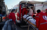 Des membres du Croissant-Rouge syrien évacuent des civils blessés qui ont trouvé refuge contre la violence dans la base russe de Hmeimim, dans la province de Lattaquié, dans l'ouest de la Syrie, le 11 mars 2025