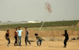 Des jeunes Palestiniens tentent de faire s'envoler un cerf-volant auquel est attaché un cocktail Molotov, le 18 avril 2018 près de la frontière entre la bande de Gaza et Israël