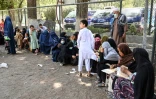 Des personnes ayant fui Kunduz et la province de Takhar déjeunent dans un parc où elles se sont réfugiées, à Kaboul, le 10 août 2021